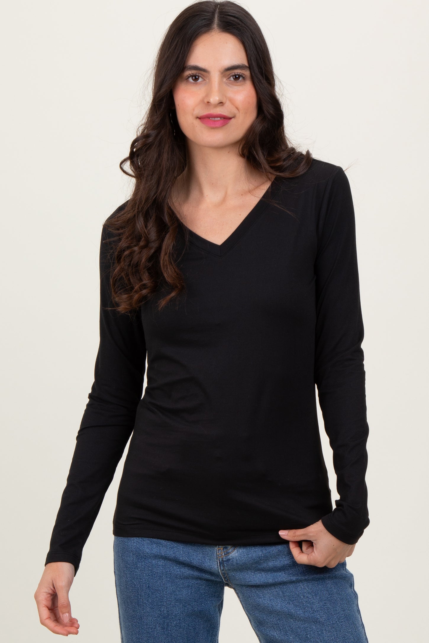 woman wearing a black long sleeve v-neck top and blue jeans
