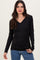woman wearing a black long sleeve v-neck top and blue jeans