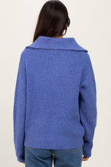 woman wearing a cozy blue sweater with a wide collar, seen from the back