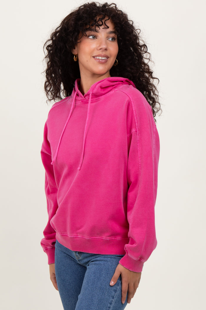 woman wearing a bright pink hooded sweatshirt with a relaxed fit and long sleeves