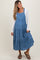 woman wearing a denim maternity maxi dress with tiered ruffles and buttons, styled with a long sleeve top and sandals