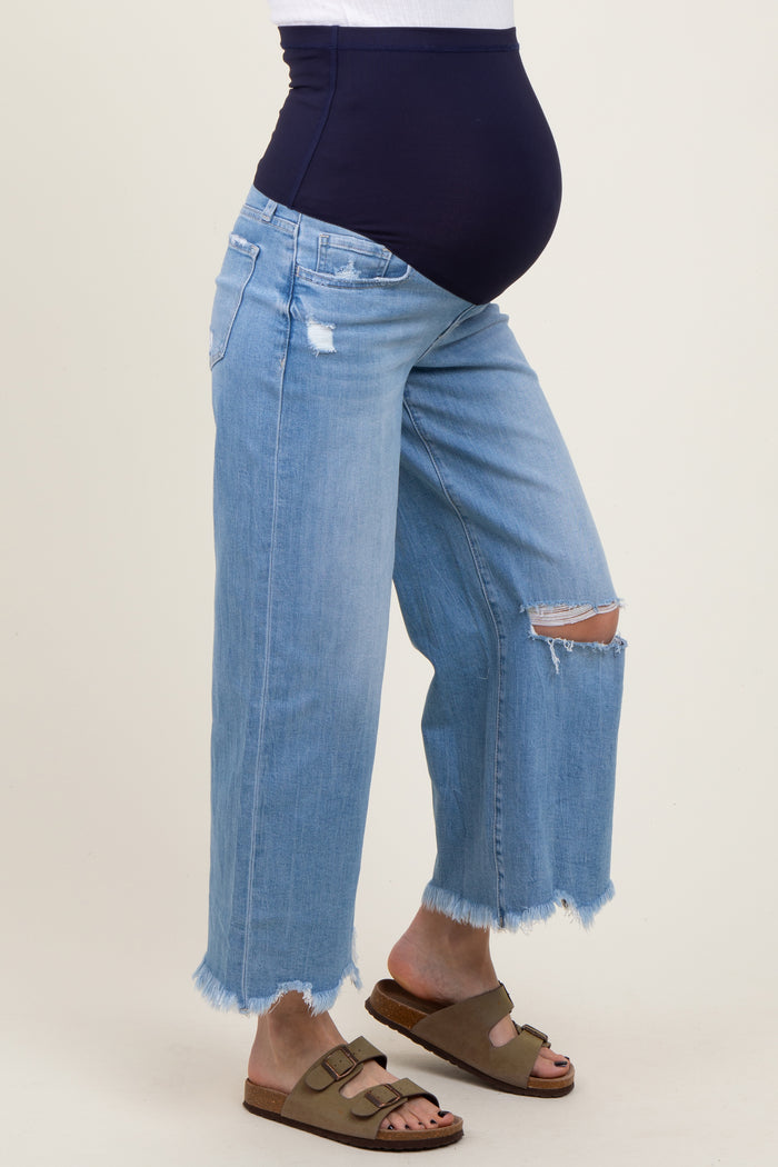 maternity wear blue distressed wide-leg jeans with a navy belly panel and a visible baby bump