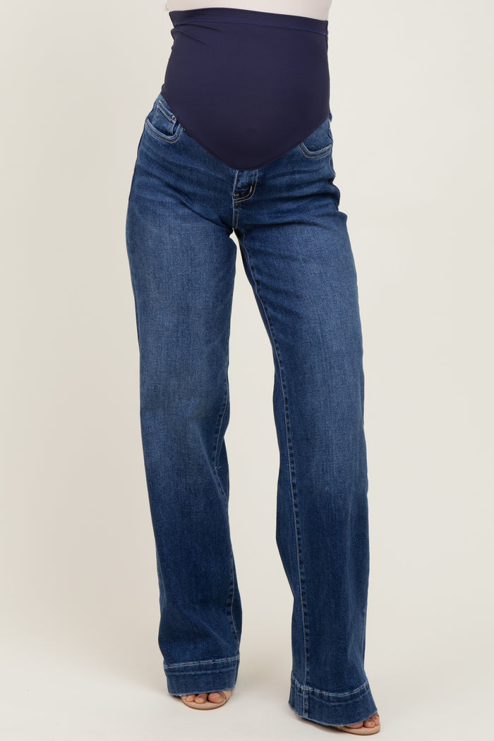 woman wearing dark blue maternity jeans with a fitted belly panel and a flared leg style