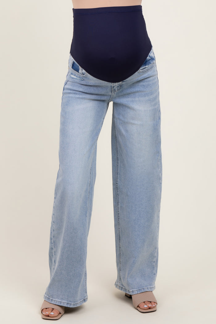 woman wearing light wash maternity wide-leg jeans with a navy blue over-the-bump waistband and neutral sandals