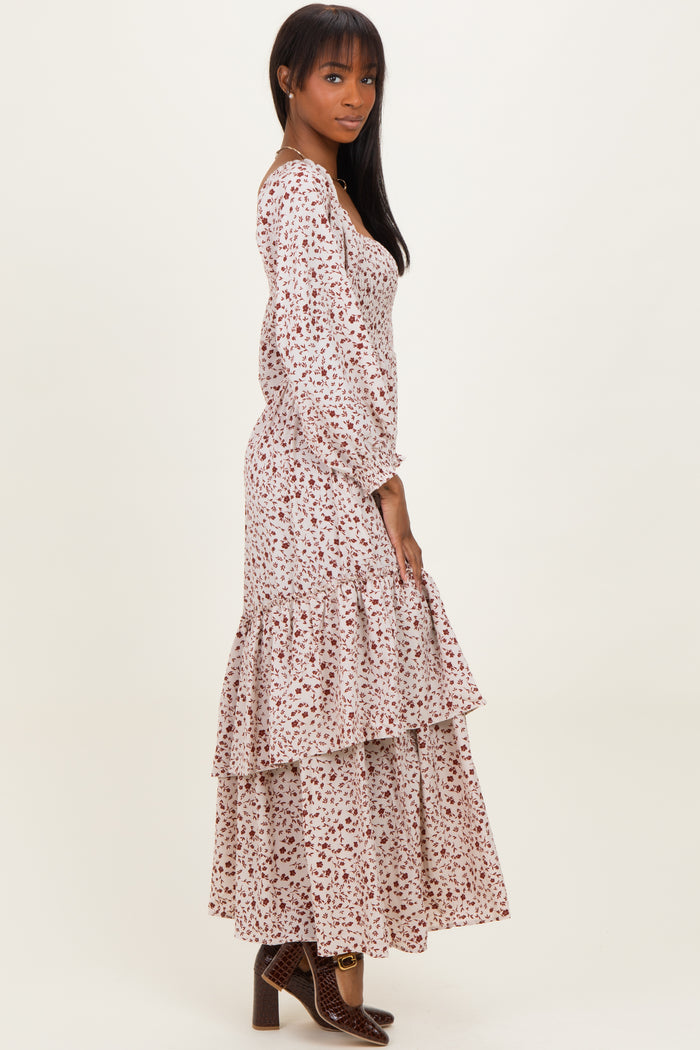 woman wearing a floral print long sleeve maxi dress with tiered ruffles and a fitted bodice