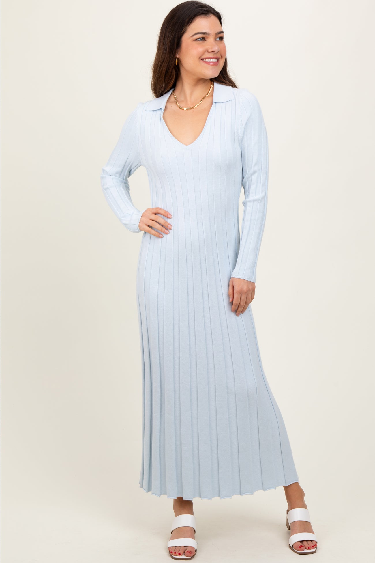 woman wearing a light blue ribbed long sleeve dress with a collared neckline and flared hem