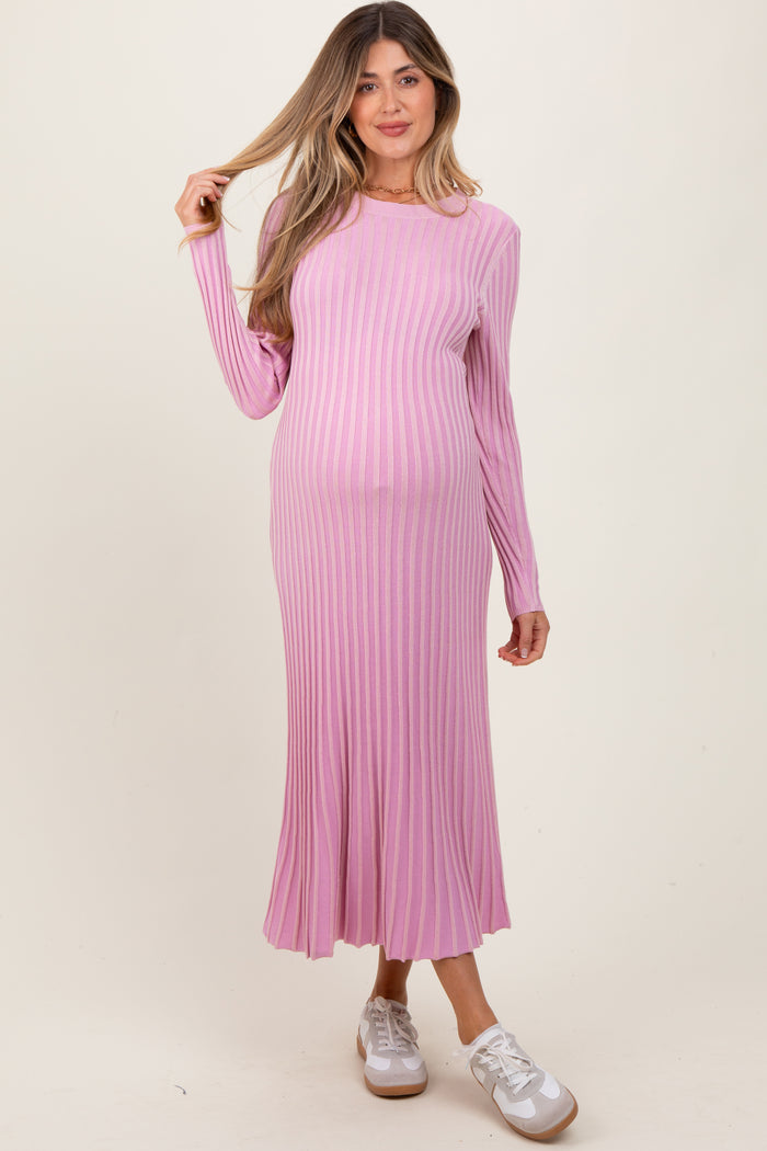 woman wearing a long sleeve light pink ribbed maternity dress with a baby bump visible