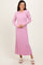 woman wearing a light pink ribbed long sleeve maxi dress with a flared hem and white sandals
