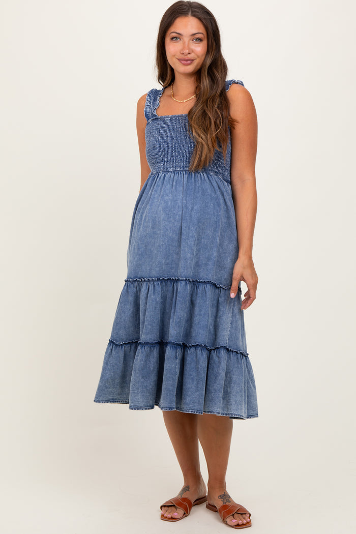 woman wearing a denim blue maternity dress with ruffled tiers and shoulder straps, showcasing a baby bump