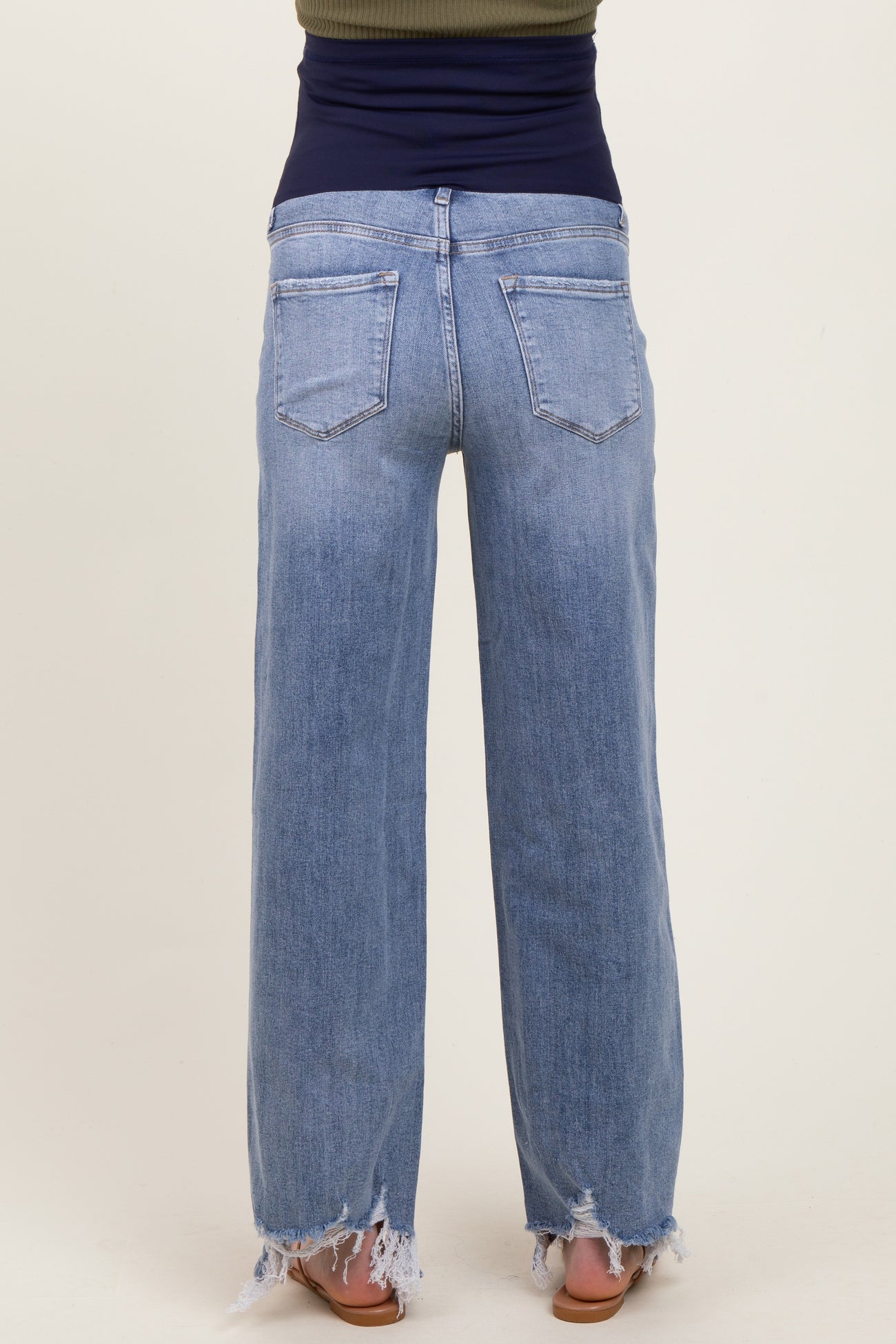 woman wearing light blue maternity wide-leg jeans with frayed hems, showing the back view