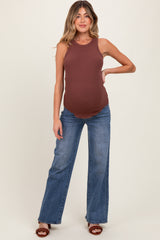 woman wearing a brown ribbed maternity tank top and blue flared jeans, showing her baby bump