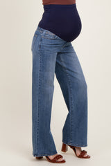 woman wearing a pair of dark wash wide-leg maternity jeans, showcasing a visible baby bump