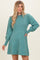 woman wearing a teal long sleeve sweater dress with puffed sleeves and a relaxed fit