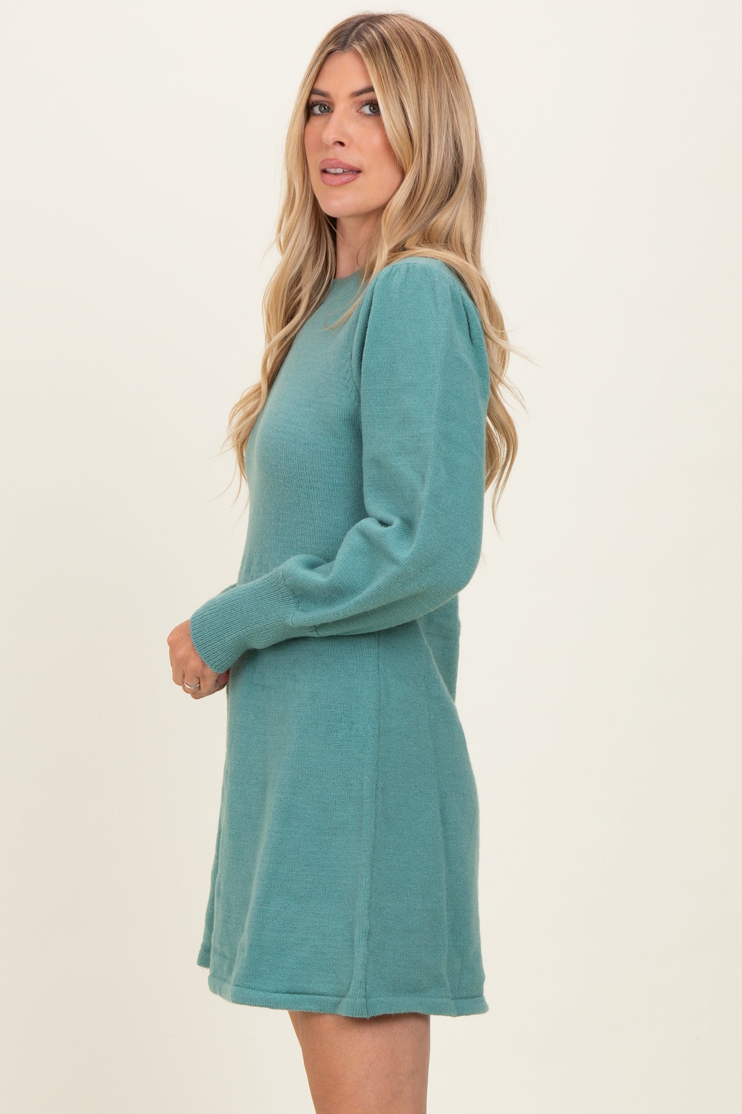 woman wearing a teal long sleeve sweater dress with a relaxed fit and side seam details