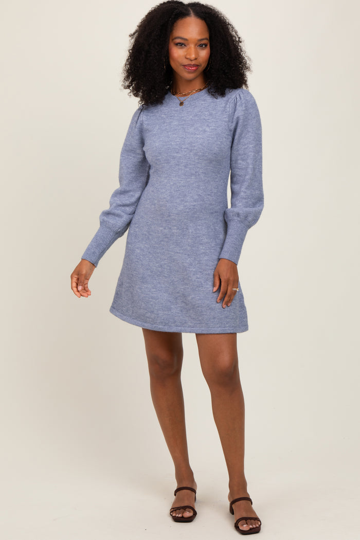 woman wearing a light blue long sleeve sweater dress with puff sleeves and a relaxed fit