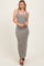 woman wearing a gray and white striped maxi dress with button details and spaghetti straps