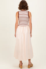 woman wearing a sleeveless striped top with a light pink maxi skirt, seen from the back
