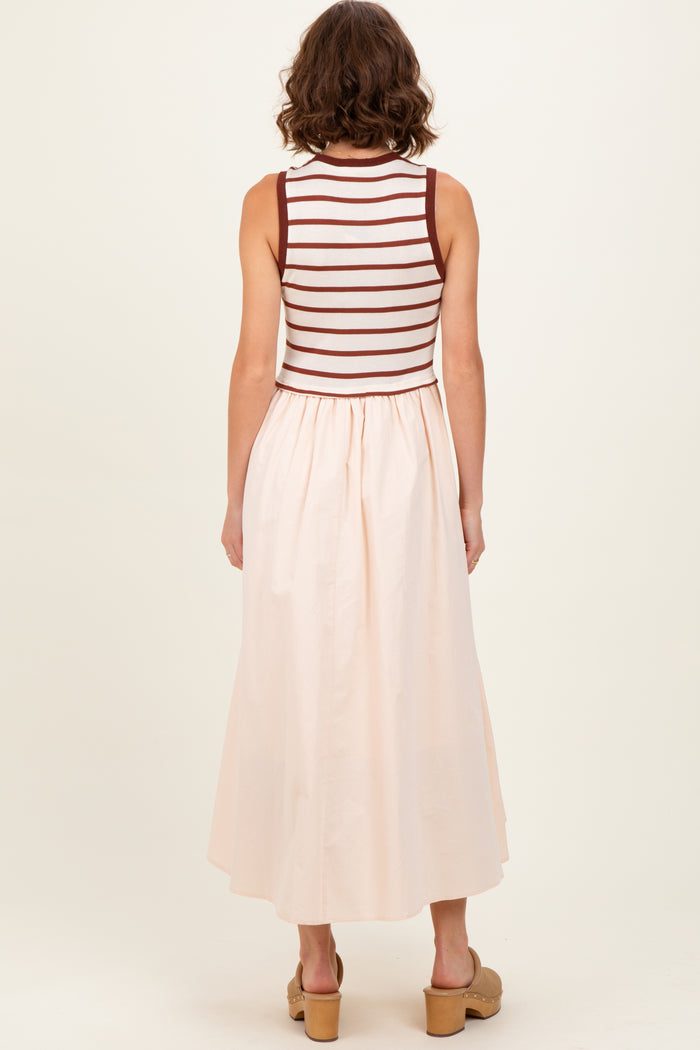 woman wearing a sleeveless striped top with a light pink maxi skirt, seen from the back