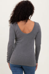 woman wearing a gray ribbed long sleeve top with a scoop back, styled with blue jeans
