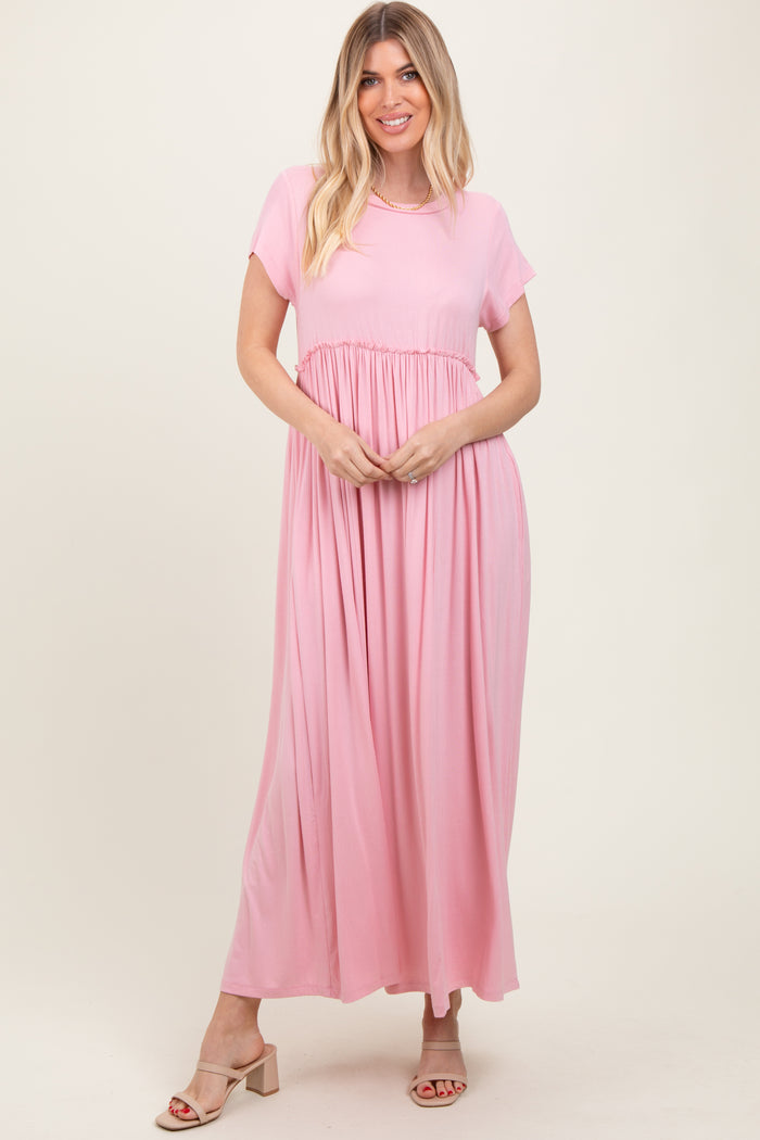 woman wearing a pink short sleeve maxi dress with a gathered waist and flowy silhouette