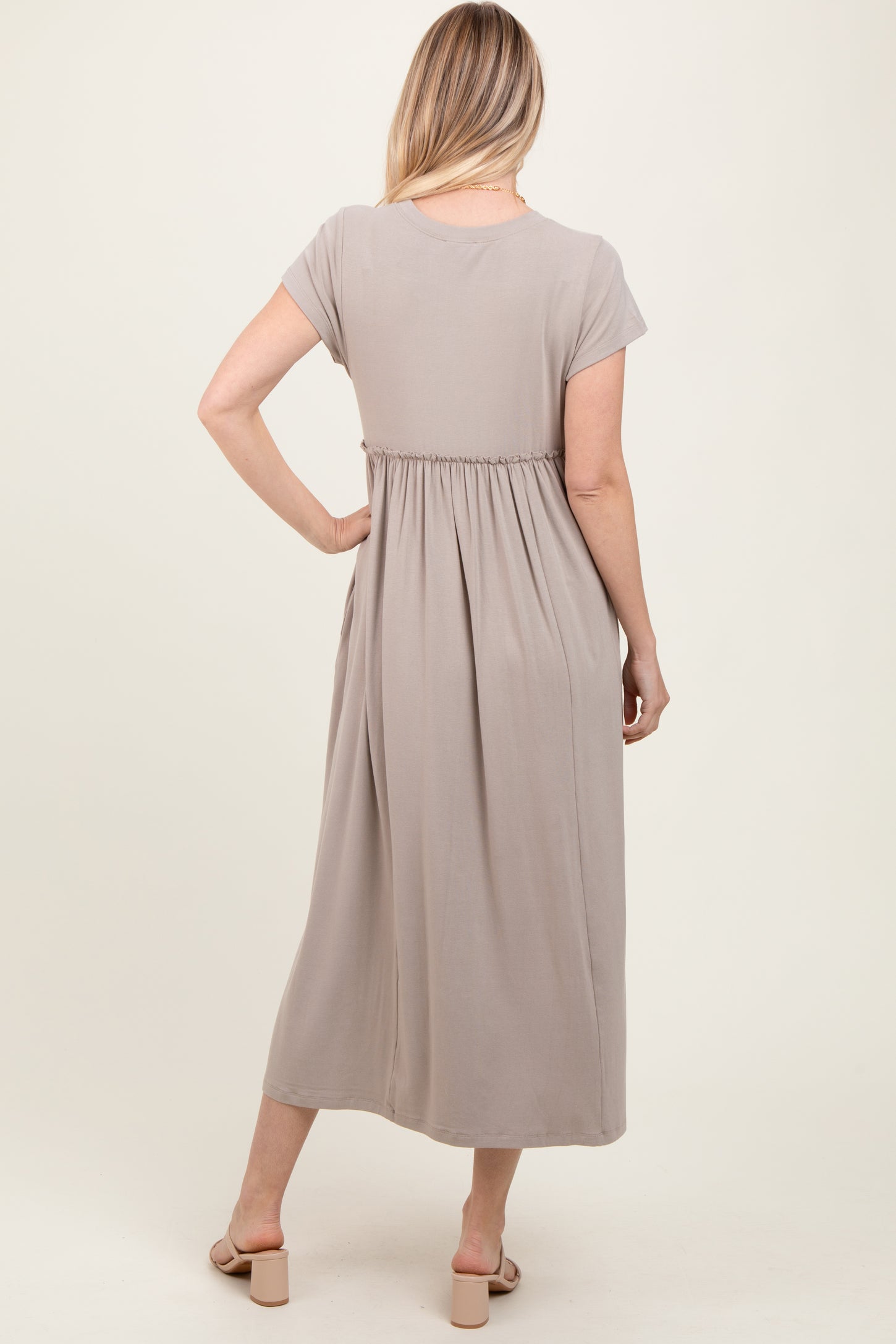 woman wearing a taupe short sleeve midi dress with a gathered waist, shown from the back