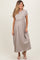 woman wearing a beige short sleeve maternity maxi dress with an empire waist and holding her baby bump