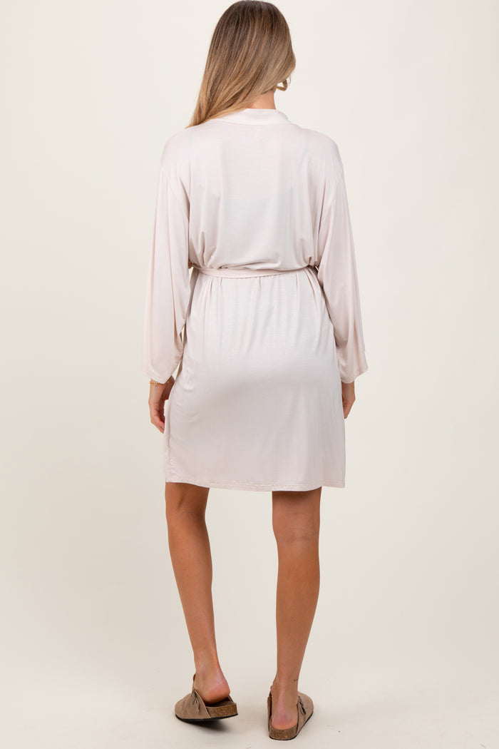 woman wearing a light pink maternity robe with a tie waist detail, shown from the back
