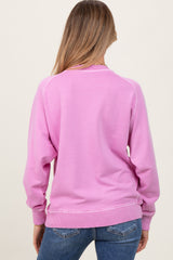 woman wearing a pink maternity sweatshirt from the back with long sleeves and ribbed cuffs