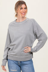 woman wearing a light gray long sleeve sweatshirt with ribbed cuffs and hem