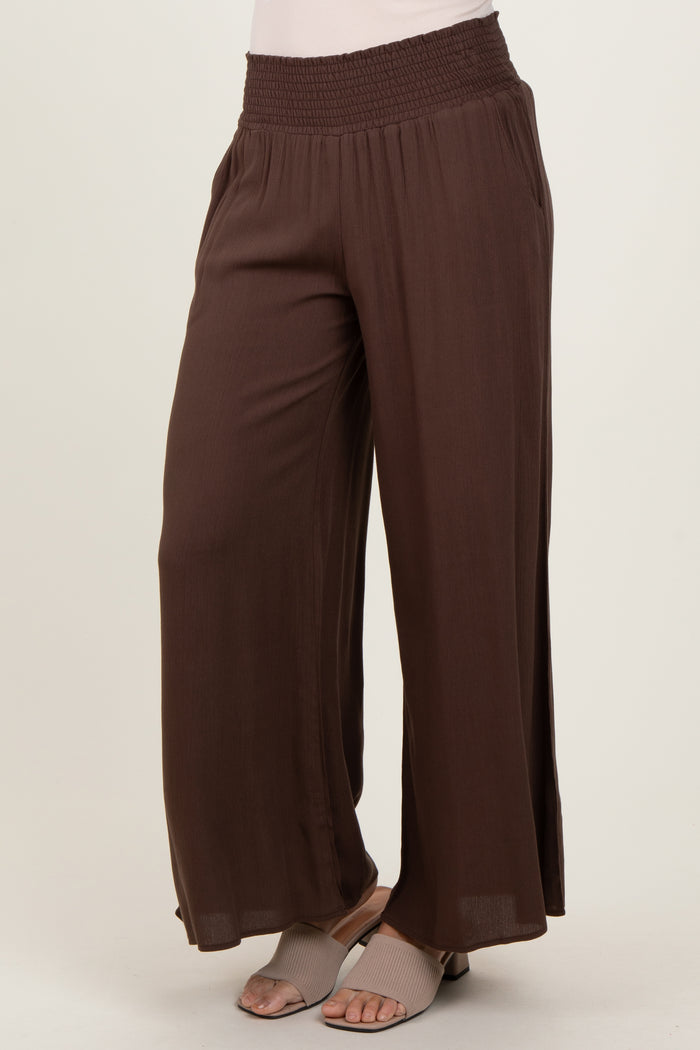 woman wearing brown high-waisted wide-leg pants with a smocked waistband