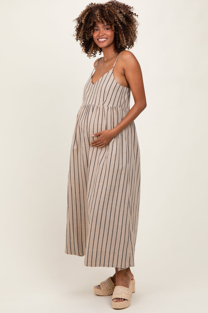 woman wearing a beige striped maternity dress with a v-neck and holding her baby bump