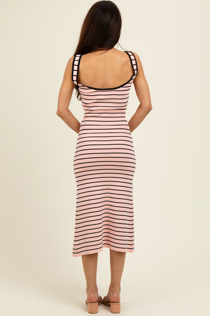 woman wearing a fitted pink and black striped midi dress with spaghetti straps and a scoop back