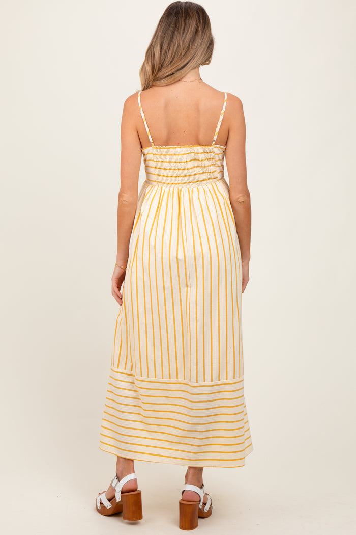 woman wearing a yellow and white striped maternity maxi dress with a smocked bodice and adjustable straps viewed from the back