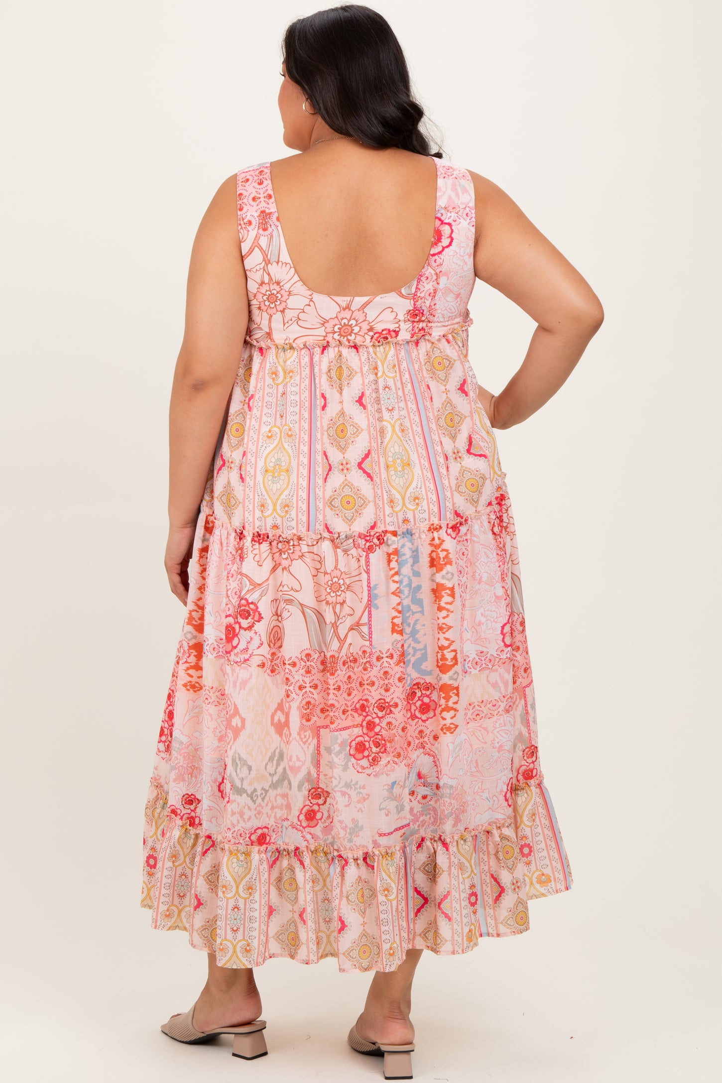 woman wearing a floral print plus-size maxi dress with a ruffled hem and a scoop back