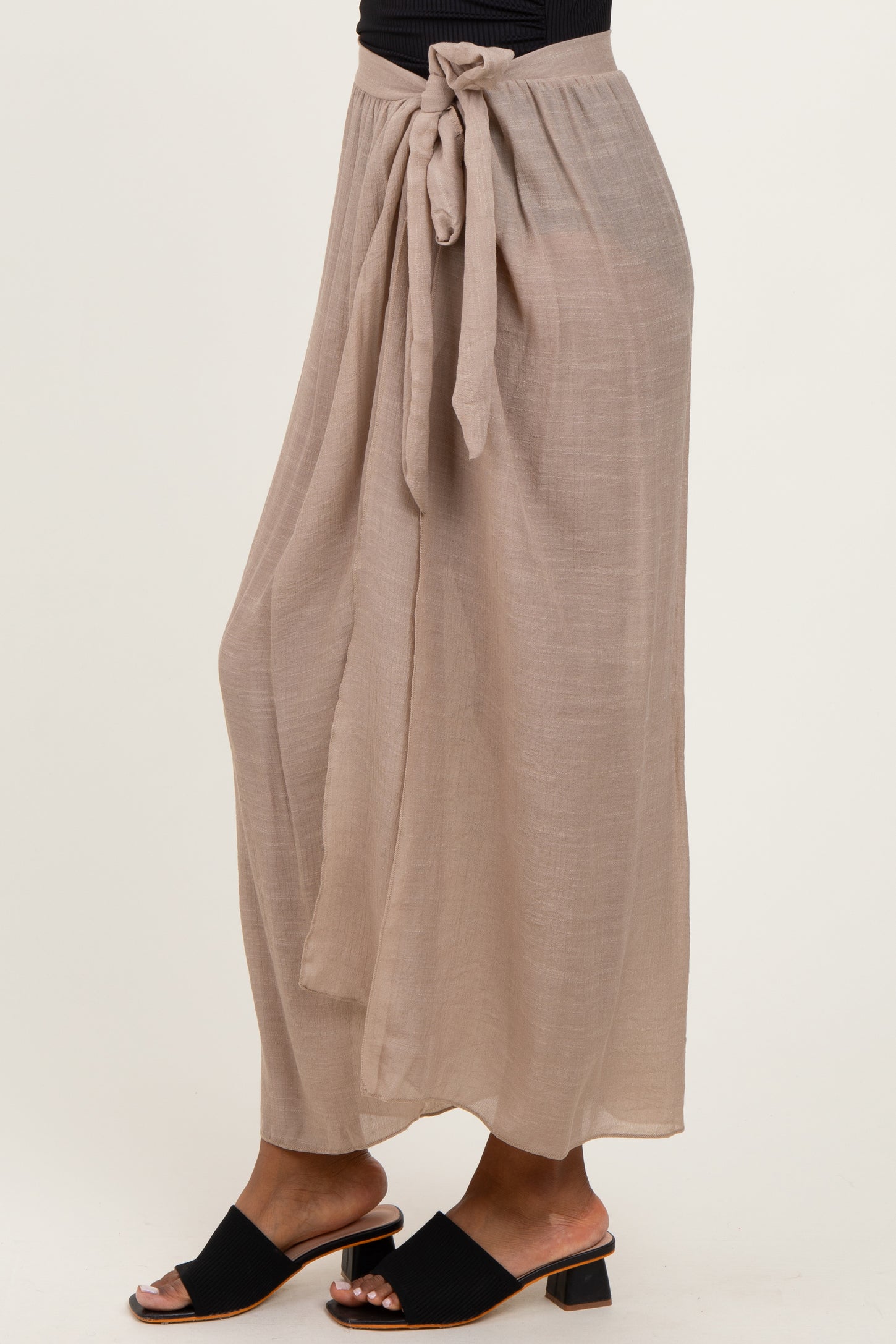 woman wearing a beige flowy maxi skirt with a tied waist and sandals
