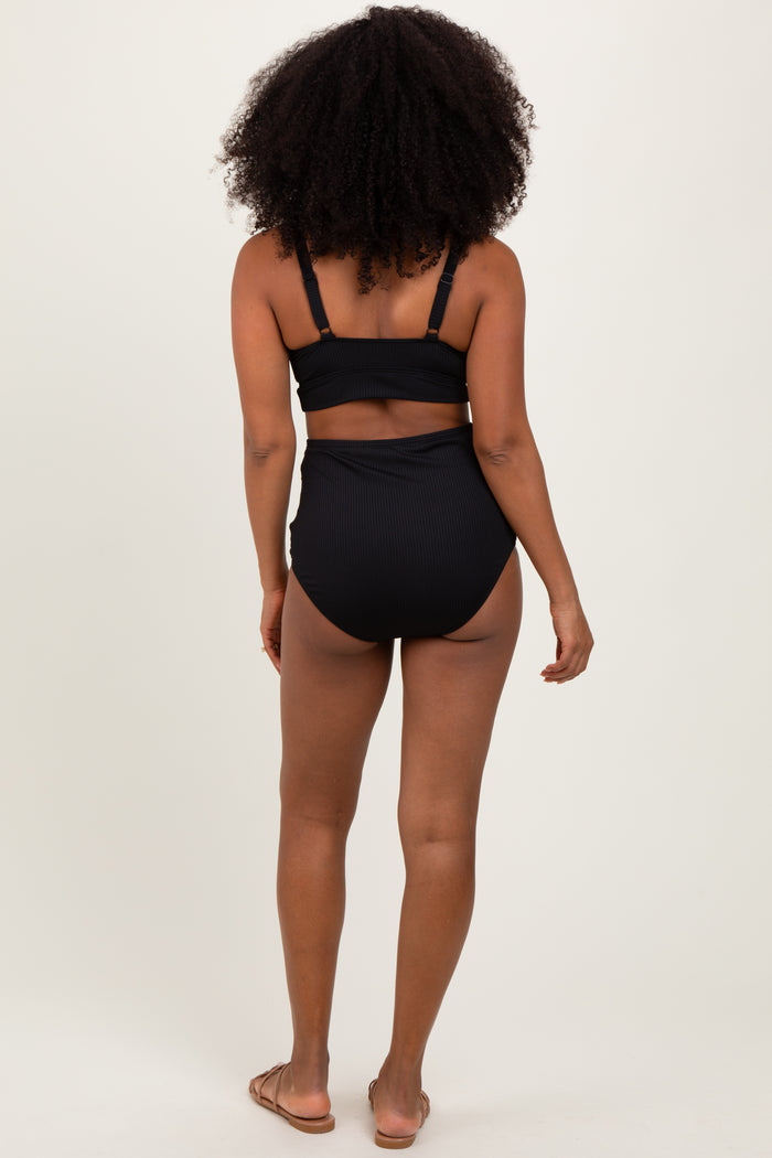 woman wearing a black ribbed high-waisted bikini set, showing the back view with adjustable straps and minimal coverage