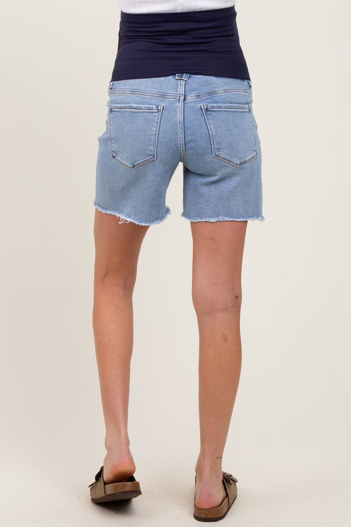 woman wearing a pair of light blue maternity denim shorts with a frayed hem and a stretchy navy waistband