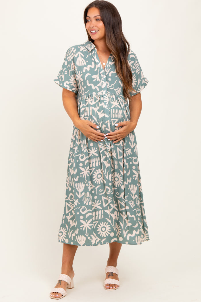 woman wearing a patterned green maternity dress with a tie waist and holding her baby bump