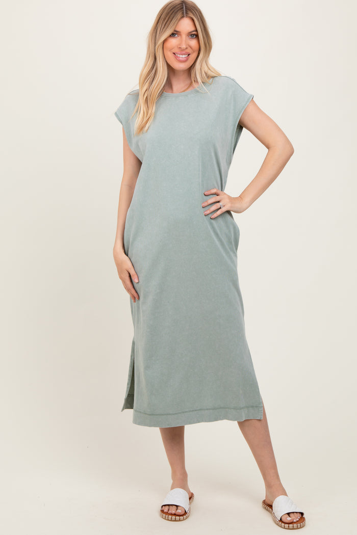 woman wearing a light green sleeveless maxi dress with side slits and white sandals