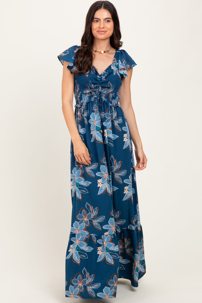 woman wearing a navy blue floral maxi dress with ruffled sleeves and a smocked bodice