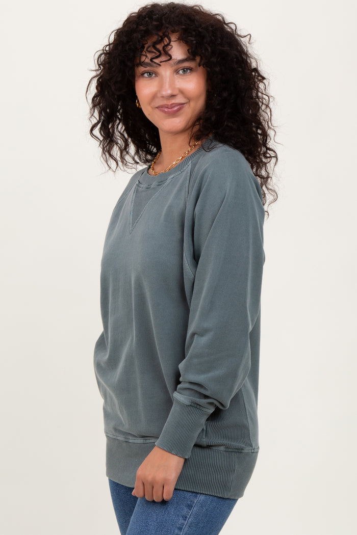 woman wearing a dusty blue oversized sweatshirt with ribbed cuffs and hem, styled casually with jeans