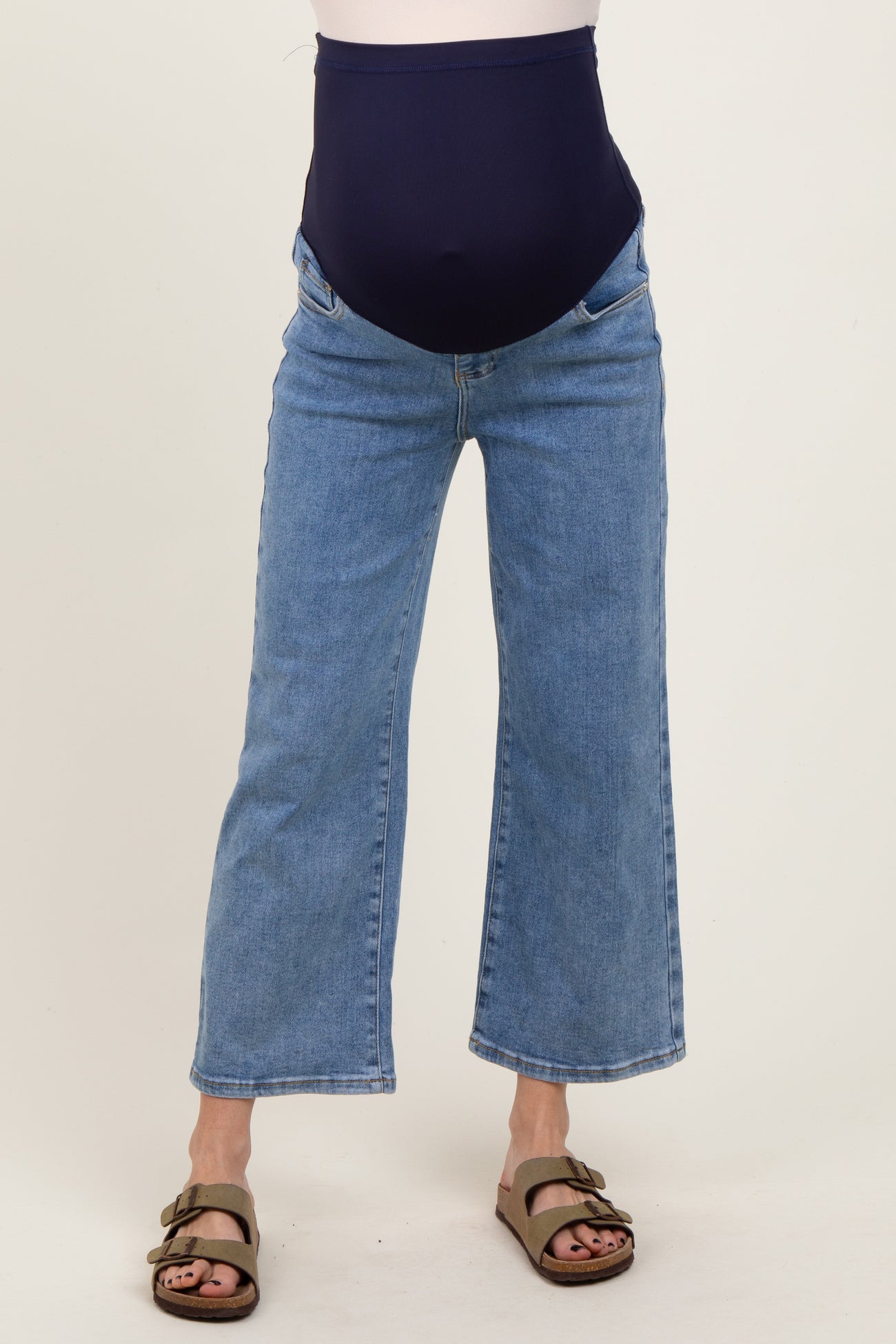woman wearing a pair of blue maternity jeans with a dark blue over-the-bump panel