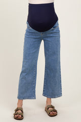 woman wearing a pair of blue maternity jeans with a dark blue over-the-bump panel
