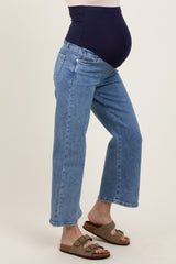 woman wearing a pair of light blue maternity jeans with a navy blue belly panel and comfortable sandals