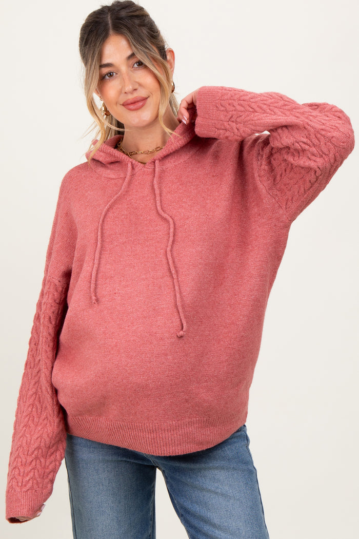 woman wearing a dusty rose maternity hoodie with cable knit sleeves and a relaxed fit, displaying her baby bump