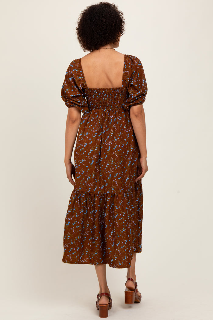 woman wearing a brown floral midi dress with puff sleeves and a square back neckline, seen from the back