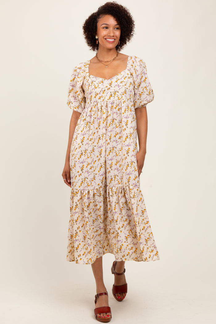 woman wearing a white floral midi dress with puff sleeves and a square neckline, standing and smiling