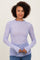 woman wearing a lavender long sleeve sheer top with heart patterns and ruffled neckline, posing with hands together
