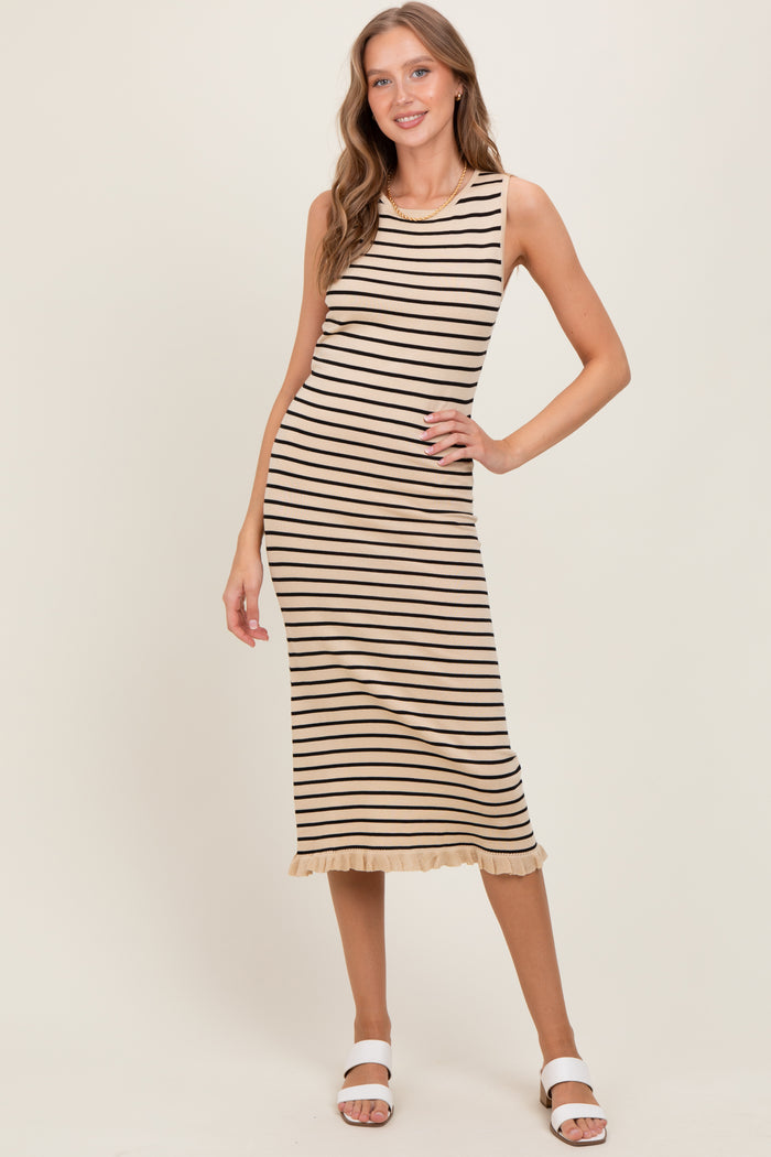 woman wearing a beige and black striped sleeveless midi dress with a ruffled hem and white sandals