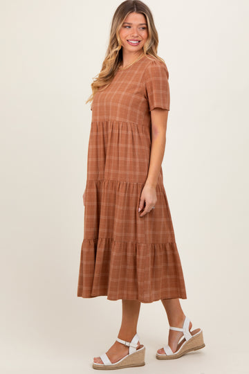 woman wearing a rust-colored short sleeve tiered midi dress with a checkered pattern and white espadrille wedges
